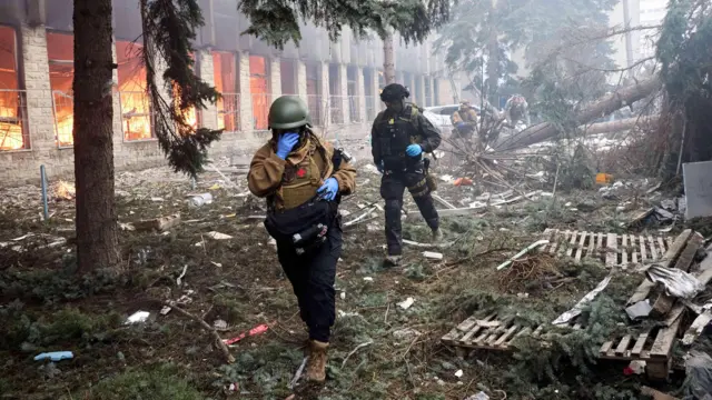 Военные среди руин и пожаров на Харьковщине во время российского штурма без бронетехники.