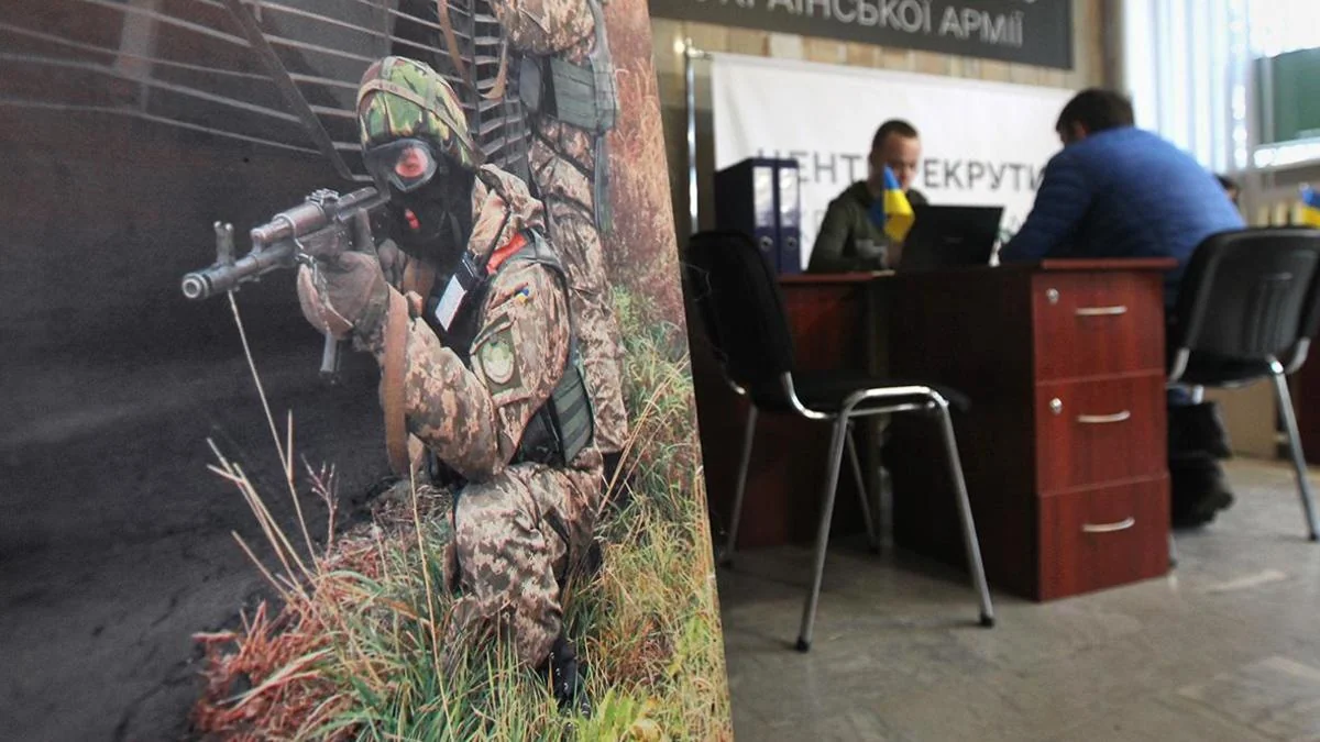 Військовослужбовець ТЦК з автоматом у камуфляжі прицілюється біля офісу комплектування.