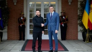 Президент Зеленский и премьер-министр Испании Педро Санчес пожимают руки перед флагами