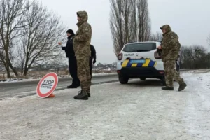 Поліцейські перевіряють документи біля патрульної машини через розшук ТЦК.