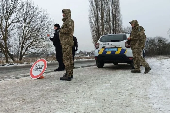 Поліцейські перевіряють документи біля патрульної машини через розшук ТЦК.