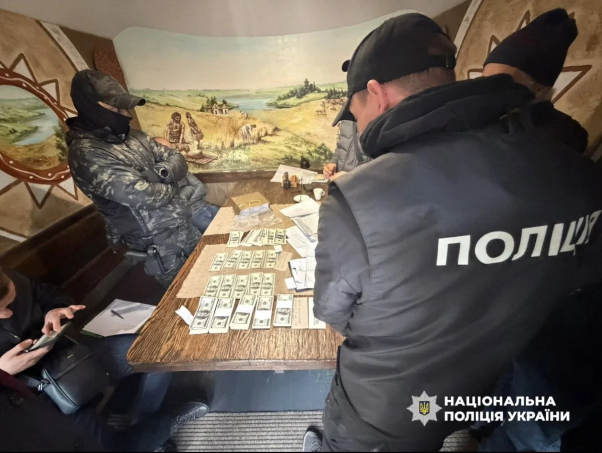 Співробітники Нацполіції фіксують хабар у 100 тис. доларів пачками стодоларових купюр під час затримання посадовця УЗ