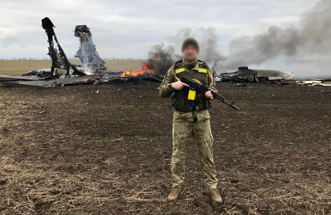 Украинский воин ЗСУ возле горящих обломков сбитого российского дрона.
