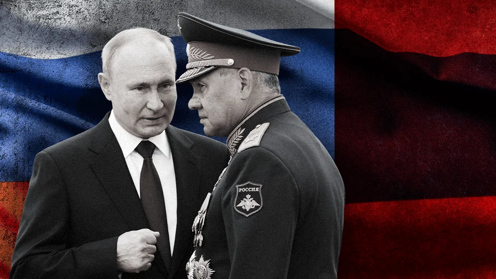 Володимир Путін розмовляє з генералом ФСБ на тлі прапора Росії.