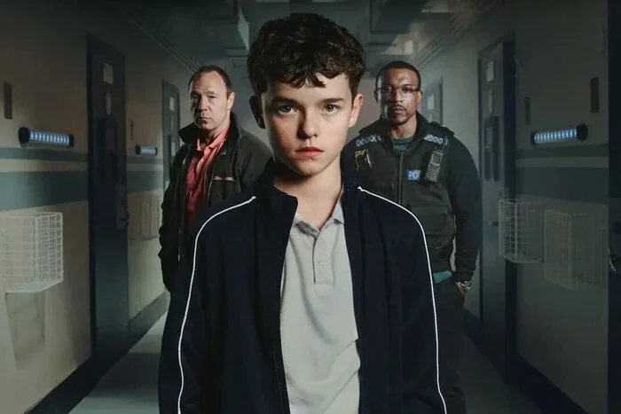 13-річний Джеймі Міллер у супроводі поліції в коридорі з серіалу Netflix «Юнацтво»