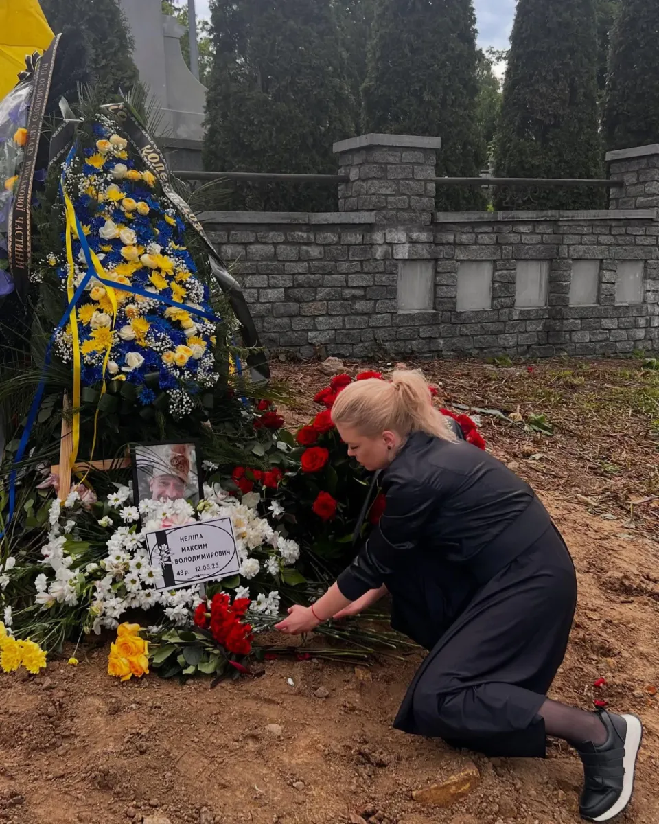 Тамара Нелипа кладёт цветы на могилу Максима Нелипы в годовщину гибели