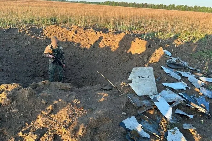 Військовий біля кратера з уламками дрона Герань-2 на Чернігівщині