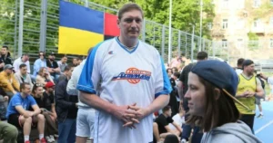 Сергій Ліщук у формі «Авангард» на баскетбольному майданчику з прапором України