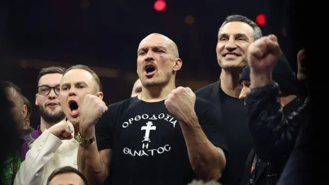 Олександр Усик з піднятими кулаками святкує перемогу над Ріко Верховеном