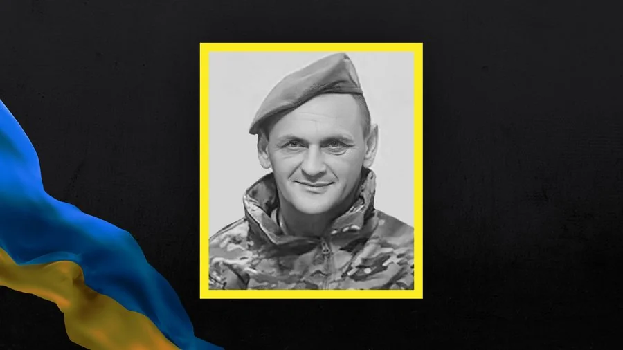 Віталій Добринський у військовій формі та береті на тлі прапора України