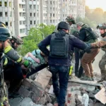 Спасатели выносят раненого из руин после атаки россиян на Харьков