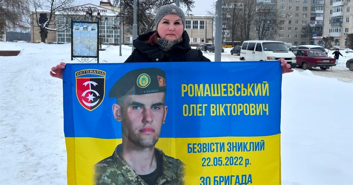 Мать держит баннер с портретом пропавшего Олега Ромашівского