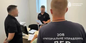 Співробітники ДБР у кабінеті розглядають документи біля компютера