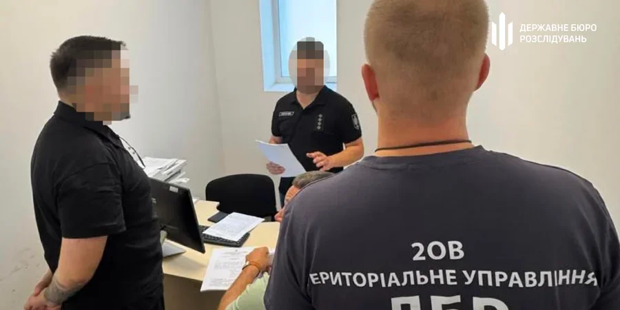 Співробітники ДБР у кабінеті розглядають документи біля компютера