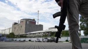 Російський військовий з автоматом на тлі реакторів Запорізької АЕС