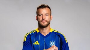 Футболіст у синій формі збірної України з гербом на грудях